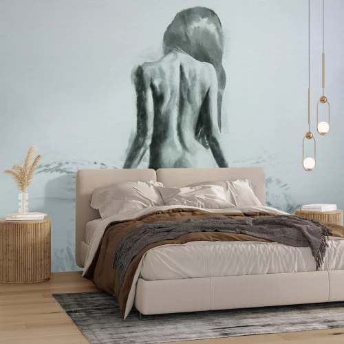 Fotobehang Een minimalistisch portret van een vrouw die op een bed zit