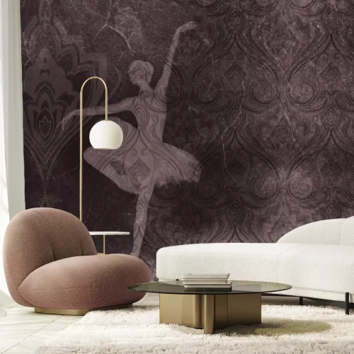 Fotobehang Een ballerina in beweging tegen een decoratief betonpatroon