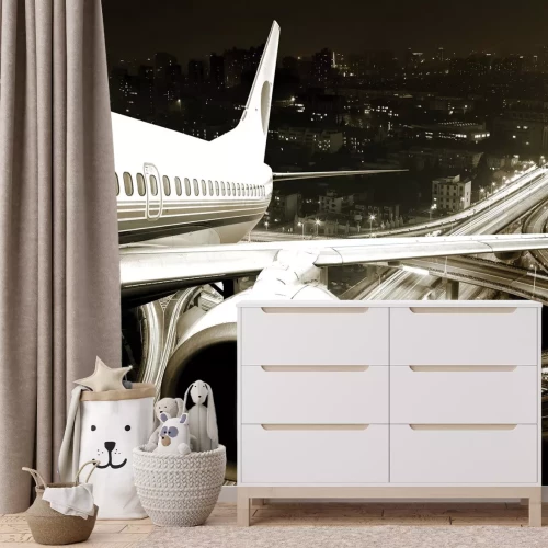 Fotobehang Een vliegtuig boven de stad &#39;s nachts