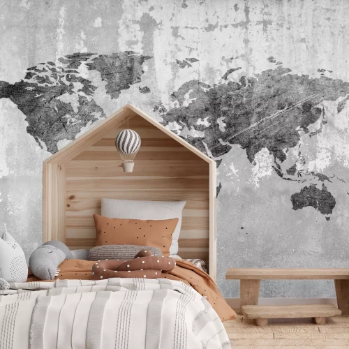 Fotobehang Een wereldkaart in grijstinten tegen een betonnen achtergrond