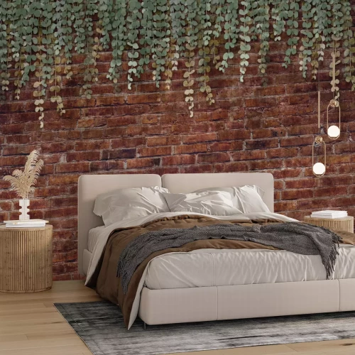 Fotobehang Groene planten hangen tegen een bakstenen muur