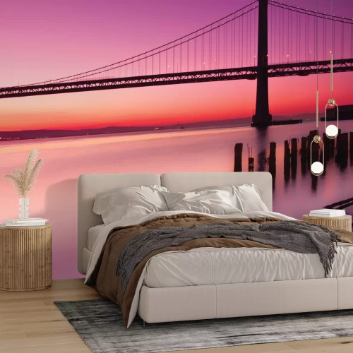 Fotobehang Landschap met een zonsondergang en een brug tegen een roze lucht