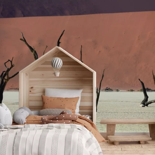 Fotobehang Een zandwoestijn met droge bomen