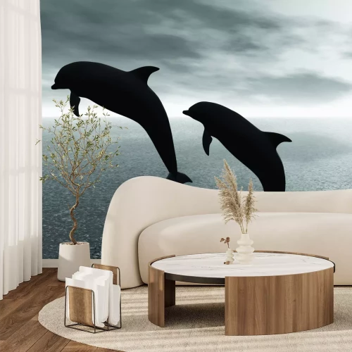 Fotobehang Een zwart-witfoto van dolfijnen boven het wateroppervlak.