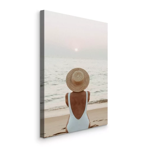 Canvas Een vrouw met een hoed zittend aan de zee