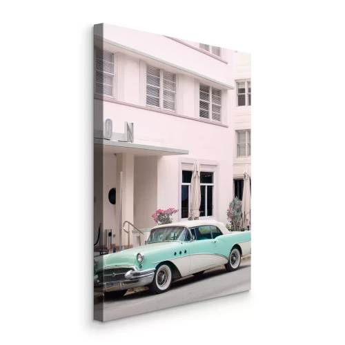 Canvas Een blauwe klassieke auto voor een roze hotel
