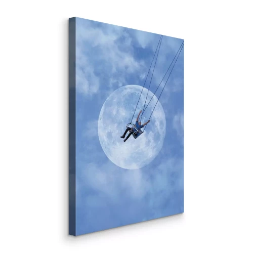 Canvas Een man op een schommel tegen een blauwe lucht met de maan
