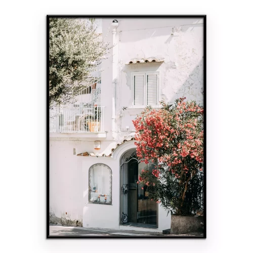 Poster Een wit huis met een bloeiende struik.