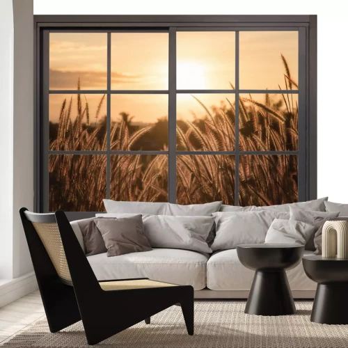 Sticker Een uitzicht vanuit het raam op de zonsondergang boven de weide.