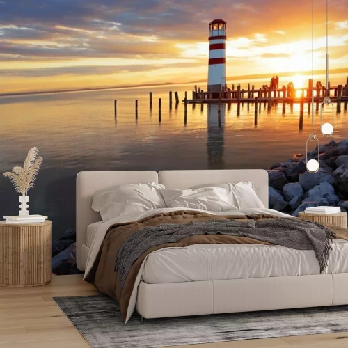 Fotobehang Vuurtoren op een rotsachtig strand