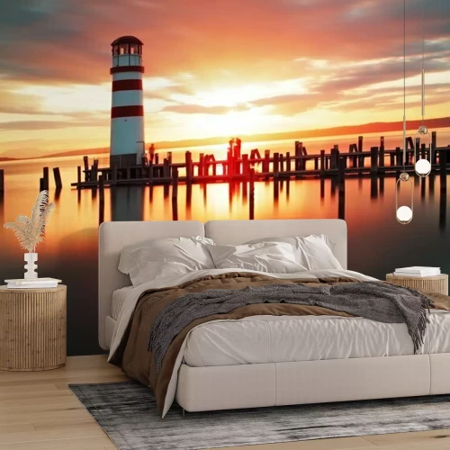 Fotobehang Een vuurtoren tegen de achtergrond van de opkomende zon