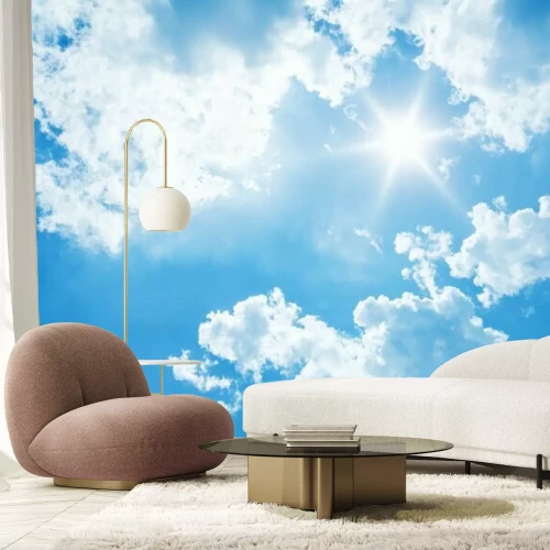 Fotobehang De zon aan een blauwe lucht met wolken