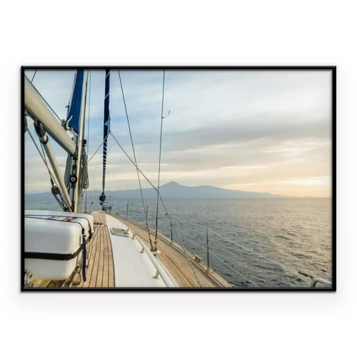 Poster Een zeilboot op zee in de stralen van de ondergaande zon.