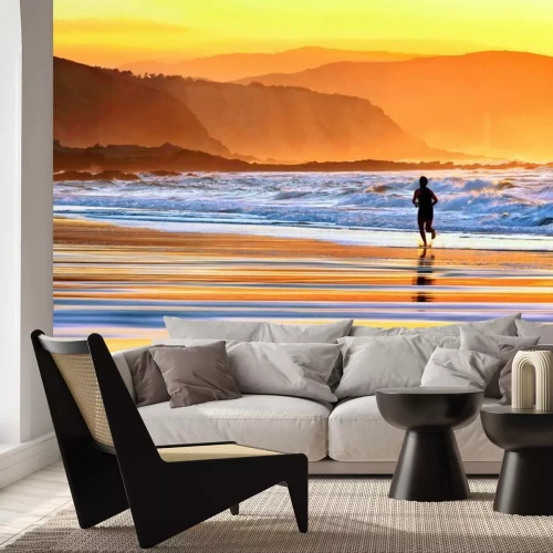 Fotobehang Man op het strand bij zonsondergang