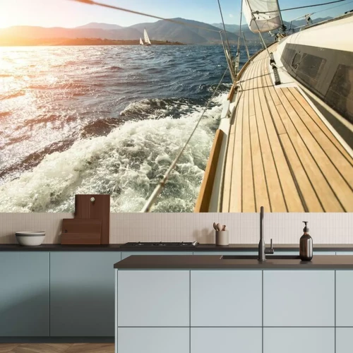 Fotobehang Een zeiljacht vaart richting de ondergaande zon