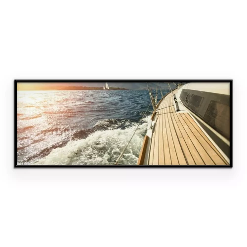 Poster Een zeiljacht vaart richting de ondergaande zon