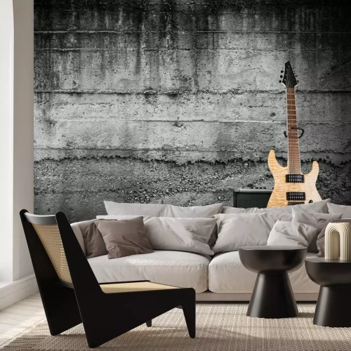 Fotobehang Een elektrische gitaar tegen een ruwe betonnen muur