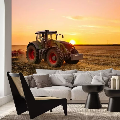 Fotobehang Tractor in een gerstveld bij zonsondergang