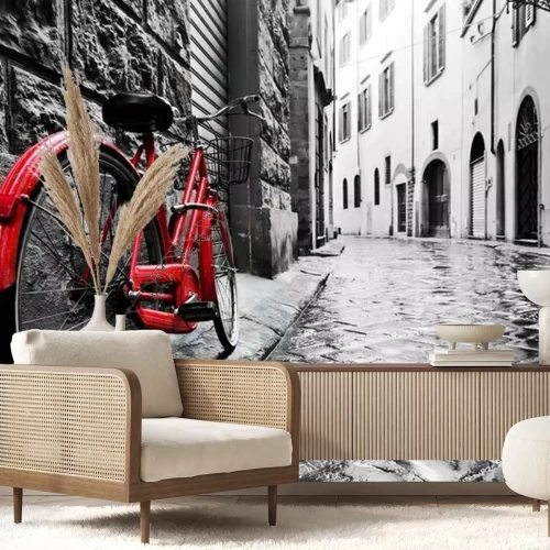 Fotobehang Retro rode fiets op een geplaveide straat in de oude stad. Kleur in zwart-wit.