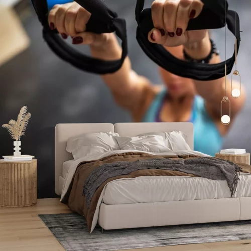 Sticker Jonge vrouw op de sportschool werkt aan haar buikspieren op trx