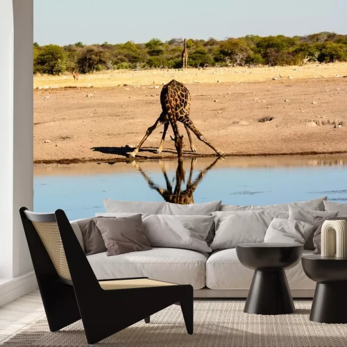 Sticker een giraffe drinken bij een waterput