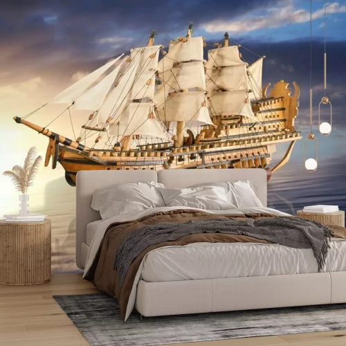 Sticker Een zeilboot tegen de achtergrond van een gouden zonsondergang.