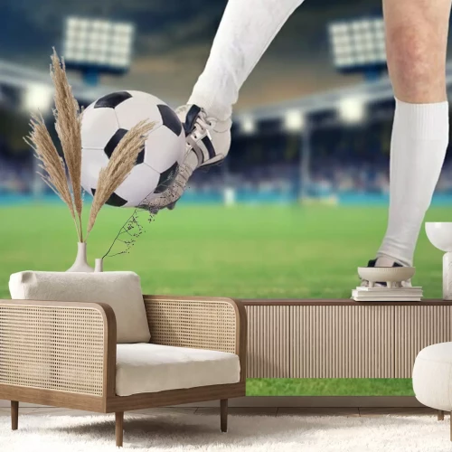 Fotobehang Een voetballer die de bal in het stadion schopt