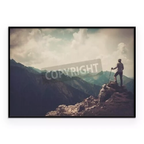 Poster Een toerist staat bovenop een berg.