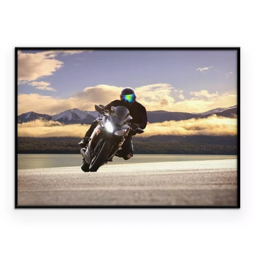 Poster Een motorrijder rijdt met bergen op de achtergrond, vermengd met wolken.