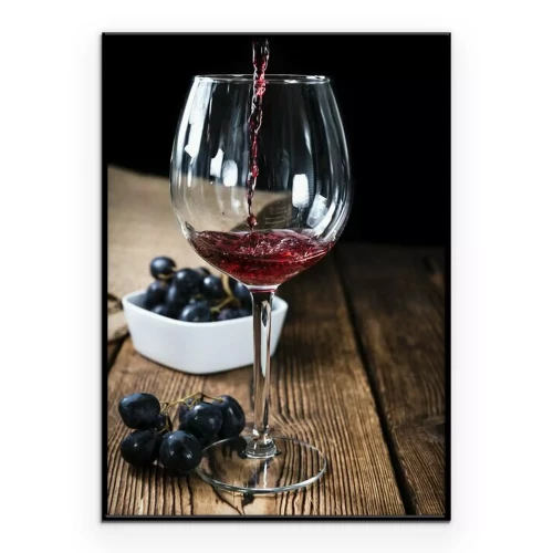 Poster Een glas rode wijn op een houten tafel.