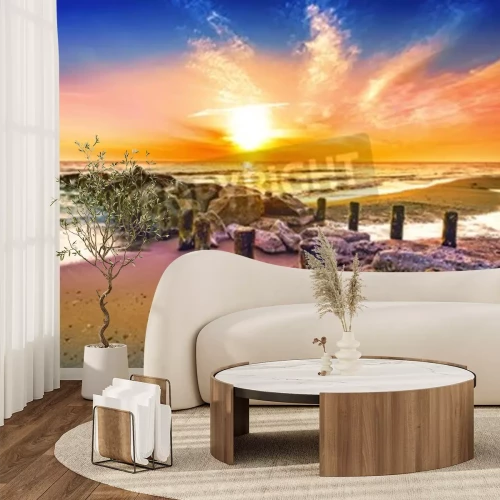 Fotobehang Zonsondergang bij een golfbreker aan de zee