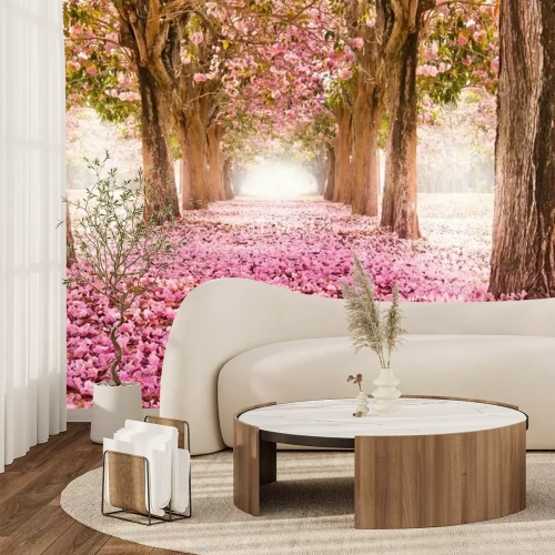 Fotobehang Een pad met roze bloemen tussen de bomen