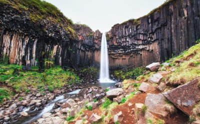 Fotobehang Landschap met een waterval tussen de rotsen