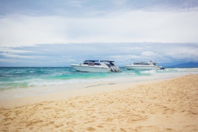 Fotobehang The cruise boats on the beach. The cruise boats parked near the sandy shore. Horizontal outdoors shot. 