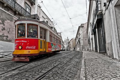 Fotobehang Uitzicht op de traditionele Tram 28 die door de straten van Lissabon, Portugal verstrekken binnenstad met het openbaar vervoer