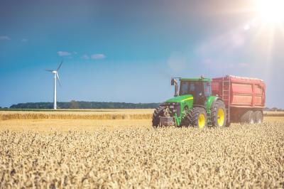 Fotobehang Tractor auf Feld mit Sonne
